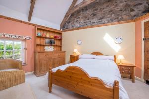 een slaapkamer met een groot bed en een stenen muur bij Ty Canol in Goodwick