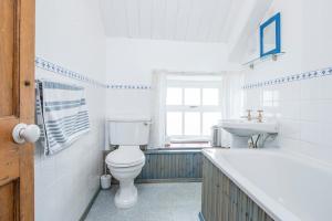 een witte badkamer met een toilet en een wastafel bij Ty Canol in Goodwick +26 foto's