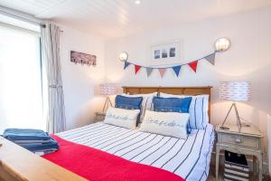 1 dormitorio con 1 cama con almohadas rojas y azules en The Boathouse, en Cardigan