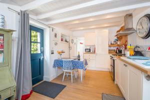 cocina con mesa y puerta azul en The Boathouse, en Cardigan