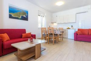 a living room with two red couches and a table at Apartments Zvone1 in Veli Rat