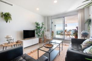 Una sala de estar con un sofá y un televisor. en Seaview apartment Alba, en Torrequebrada