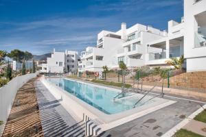 Una imagen de un gran edificio de apartamentos blanco con piscina. en Seaview apartment Alba, en Torrequebrada