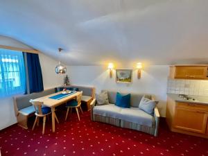 a living room with a couch and a table at Die Bergretter Appartements in Ramsau am Dachstein