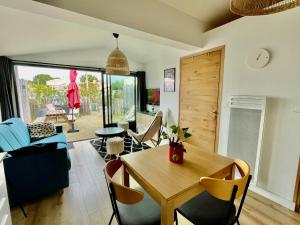 a living room with a wooden table and chairs at NOIRMOUTIER - Petite maison 500m plage Sableaux in Noirmoutier-en-l'lle