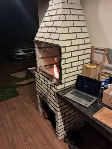 a brick fireplace with a laptop on top of it at Recanto da Natureza in Itabirito