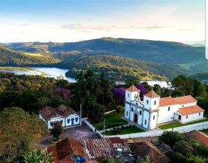 an aerial view of a town with a lake and a building at Recanto da Natureza in Itabirito