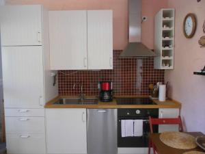 a kitchen with white cabinets and a sink at Marie's Apartment in Detmold