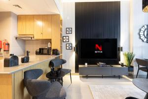a living room with a tv and some chairs at 1BR Private Apartment in Center of Sharjah- Black Knight in Sharjah