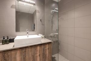 a bathroom with a sink and a mirror and a shower at 1BR Private Apartment in Center of Sharjah- Black Knight in Sharjah