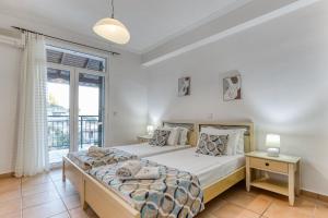 a bedroom with a bed and a large window at Kaminaki Villas by Tsiolis Family in Katávolos