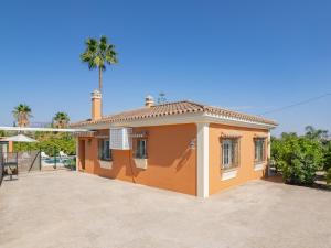a small orange house with a palm tree in the background at Cubo's Casa Rural Huertas Viejas High Privacy in Coín