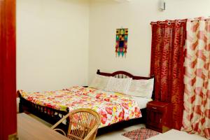 ein Schlafzimmer mit einem Bett und einem Stuhl darin in der Unterkunft Leelu Homestay in Kochi + 5 Fotos