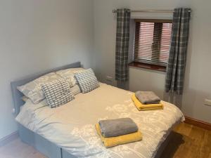 a bed with two towels on it in a bedroom at The Barn in Baltonsborough