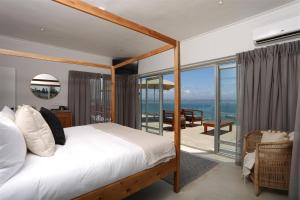 una camera da letto con un letto e vista sull'oceano di The Lookout Guest House a Mossel Bay