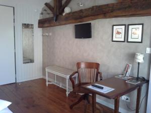 Habitación con escritorio, silla y mesa. en Le Logis Du Four en Soudan