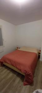 Bett in einem weißen Zimmer mit einer roten Tagesdecke in der Unterkunft Villa d'Orée, Bordeaux Saint-Aubin-de-Médoc in Saint-Aubin-de-Médoc