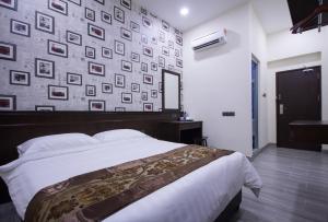 a bedroom with a bed and a wall of pictures at Island Guesthouse - Previously known as Islander Lodge in George Town