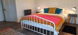 a bedroom with a bed with colorful blankets and pillows at The Studio Trewarveneth Manor Farm TR185NF in Newlyn