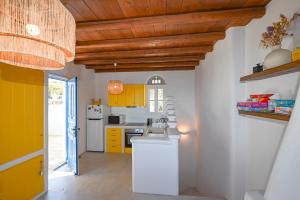 a kitchen with yellow cabinets and a wooden ceiling at Arnados House View in Arnados