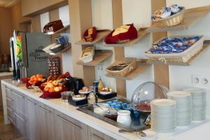 a kitchen with a counter with plates and food on it at Hôtel l'Aragon à 50m de la cité de Carcassonne in Carcassonne