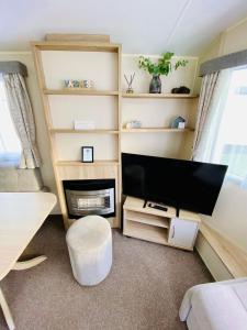 Televiisor ja/või meelelahutuskeskus majutusasutuses GWENNAP RETREAT - 3 bedroom self catering caravan close to Porth beach