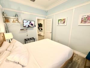 een slaapkamer met een bed en een tv aan de muur bij Atocha Cottage - Harbor Walk Hideaways in Key West +8 foto's