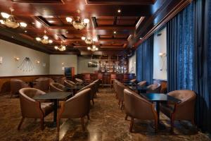 un ristorante con tavoli e sedie e un bar di Radisson Blu Hotel, Muscat a Mascate Altre 37 foto