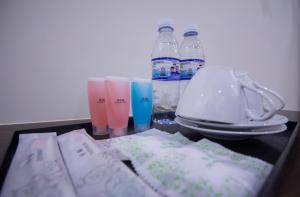 a table with some bottles and glasses and some paper at Island Guesthouse - Previously known as Islander Lodge in George Town