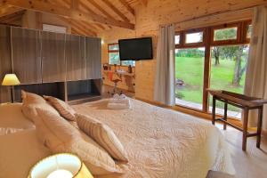 a bedroom with a bed and a television in a cabin at Cabañas Sierra Serena in Villa General Belgrano +17 photos