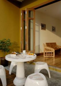 a white table and chairs in a room with a table and chairs at Jerung Hotel in Khao Lak