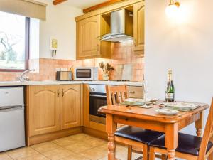 a kitchen with wooden cabinets and a wooden table at May Cottage-Uk38279 in Cloughton