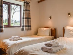 two beds in a room with towels on them at May Cottage-Uk38279 in Cloughton