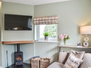 a living room with a fireplace and a tv at The Hen House - Uk38436 in Kilham