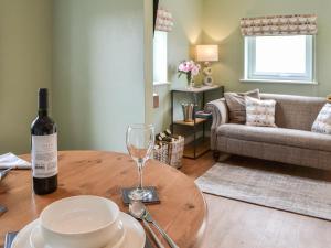a bottle of wine sitting on a table with a wine glass at The Hen House - Uk38436 in Kilham +18 photos