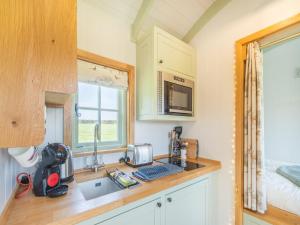 a kitchen with a counter with a sink and a window at The Wensleydale - Uk40152 in Rathmell