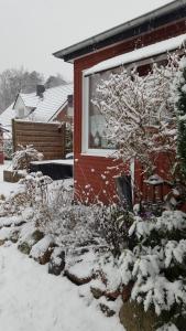 una casa con nieve en las ramas de un árbol en Ferienhaus Weiser, en Cuxhaven