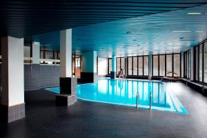 een zwembad in een gebouw met een persoon erin bij Hotel Mirella in Ponte di Legno