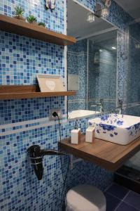 サレルノにあるIcon Livingの青いタイル張りのバスルーム(シンク、鏡付)