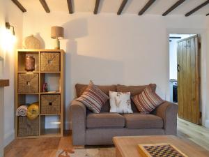 a living room with a couch and a table at Maisies Cottage in Wirksworth