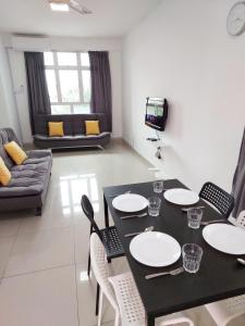 a living room with a black table and chairs at TuR05-Pisa Stadium-3room-Private in Bayan Lepas