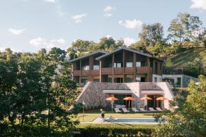 a building with a pool and orange umbrellas at ANTON Nature Hideaway in Natz-Schabs