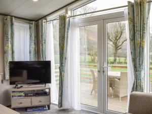 a living room with a tv and a sliding glass door at Dodd - Uk42499 in Bassenthwaite