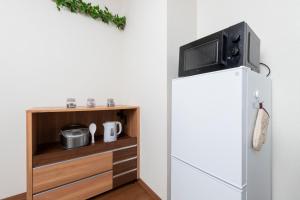 a tv on top of a refrigerator in a kitchen at Kosumosu in Tokyo
