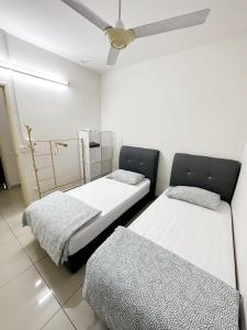 a room with two beds and a ceiling fan at TuR05-Pisa Stadium-3room-Private in Bayan Lepas