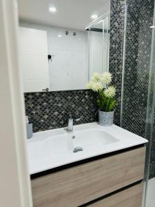 a bathroom with a white sink and a shower at Loft Capadocia 1A in Vinarós +2 photos