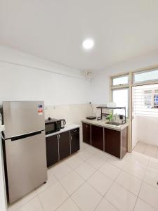 an empty kitchen with a refrigerator and a sink at TuR05-Pisa Stadium-3room-Private in Bayan Lepas +8 photos