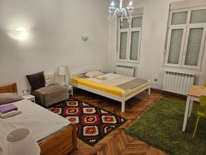 a room with a bed and a couch and a chair at Cricket 2 Hostel in Belgrade