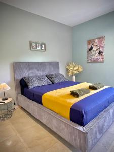 a bedroom with a large bed with blue and yellow sheets at Villa Rose Marie Chambres dhôtes au Calme et Grands Espaces in Le François +59 photos