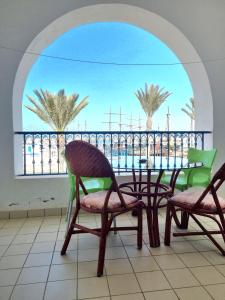 un balcon avec une table, des chaises et des palmiers dans l'établissement Houmet Souk Marina, à Djerba